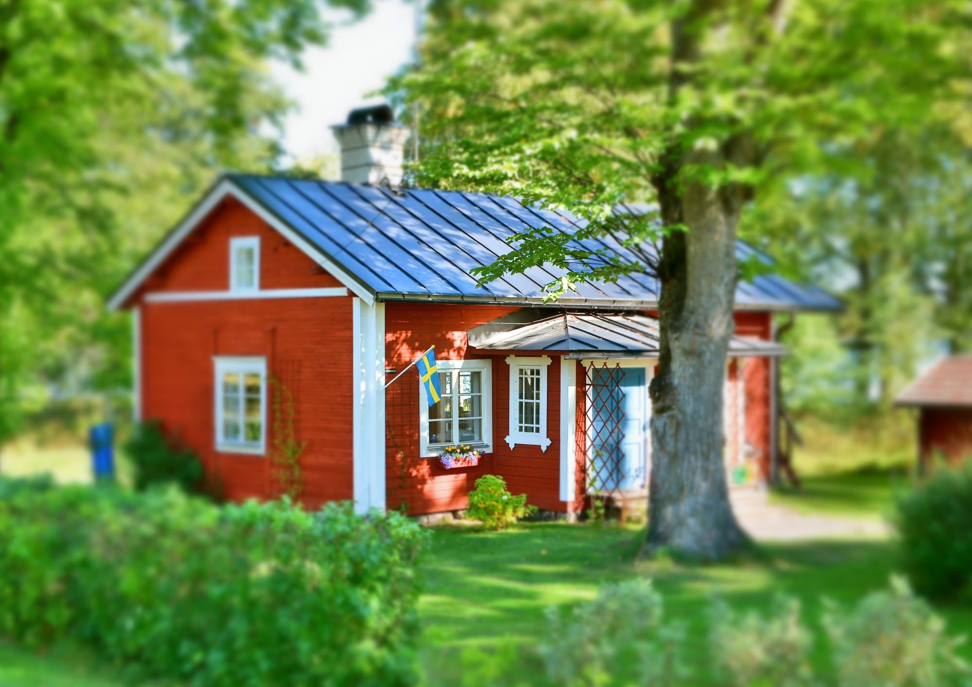 Rotes Häuschen mit Blechdach im Garten