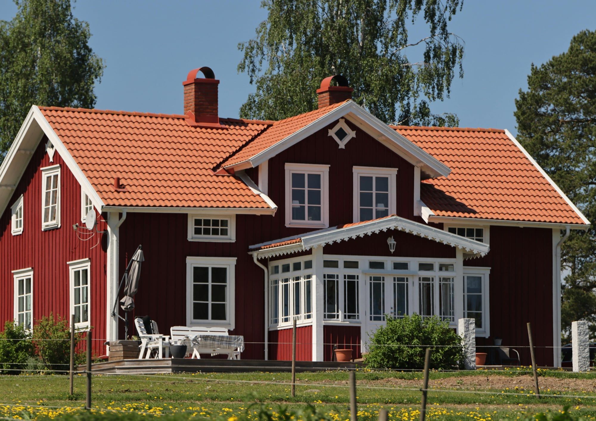 Großes rotes Holzhaus mit Glasveranda